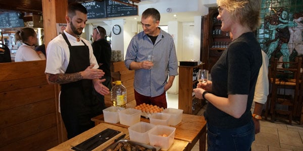 Gourmetkokke der underviser gæster i at åbne østers.